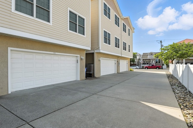 305 E Bennett Ave Unit A, Wildwood, NJ 08260 - view of property exterior with an attached garage, concrete driveway, and stucco siding