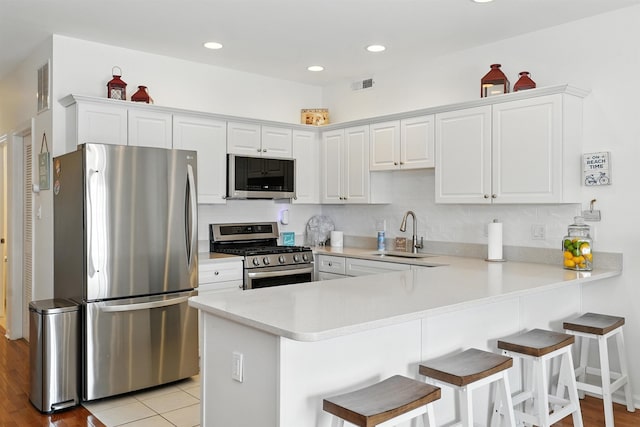 305 E Bennett Ave Unit A, Wildwood, NJ 08260 - kitchen with appliances with stainless steel finishes, a peninsula, light countertops, a kitchen bar, and recessed lighting