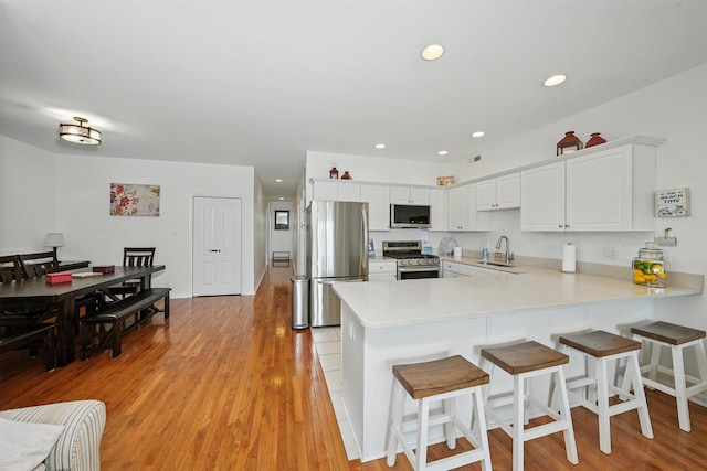 305 E Bennett Ave Unit A, Wildwood, NJ 08260 - kitchen featuring stainless steel appliances, a peninsula, light countertops, light wood-type flooring, and recessed lighting