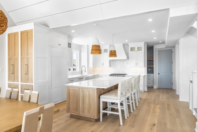 242 83rd St, Stone Harbor, NJ 08247 - kitchen featuring premium range hood, a center island, light countertops, backsplash, and glass insert cabinets