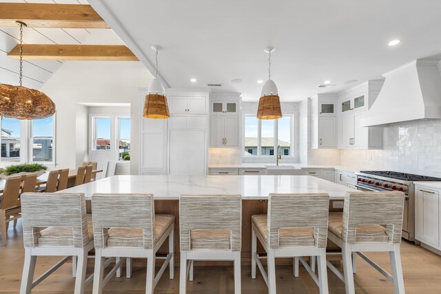 242 83rd St, Stone Harbor, NJ 08247 - kitchen with designer range, custom range hood, healthy amount of natural light, a center island, and recessed lighting