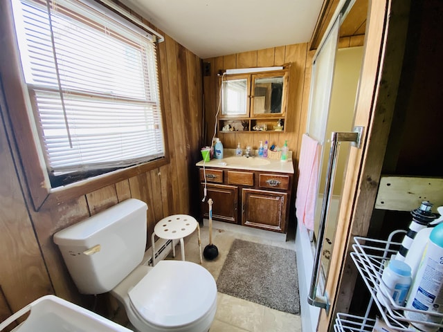 bathroom featuring vanity, wood walls, a shower, tile patterned flooring, and toilet