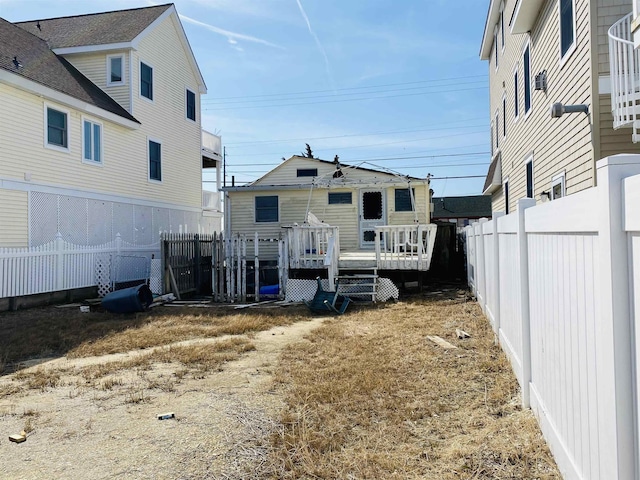 rear view of house featuring a wooden deck