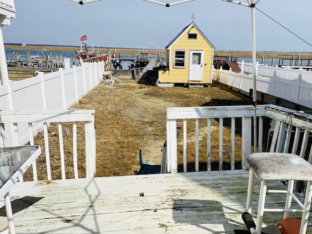 view of yard with a deck with water view and a shed