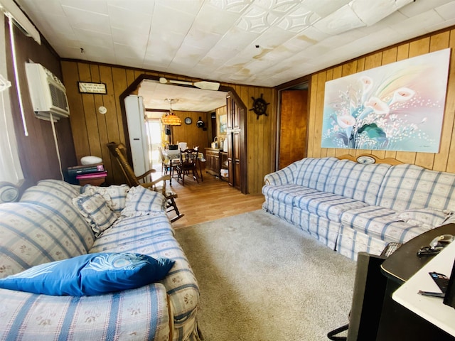 carpeted living room with wooden walls