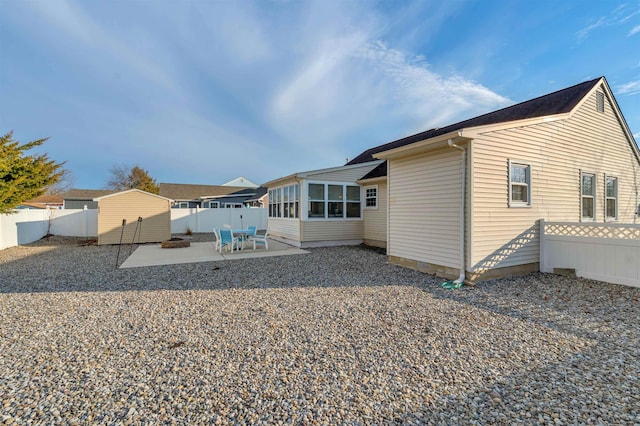 back of property featuring a sunroom, a patio area, and a fenced backyard