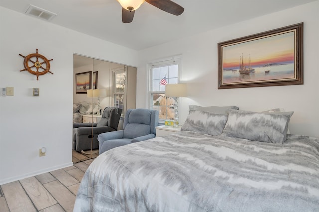 bedroom featuring light wood finished floors, visible vents, baseboards, a ceiling fan, and a closet