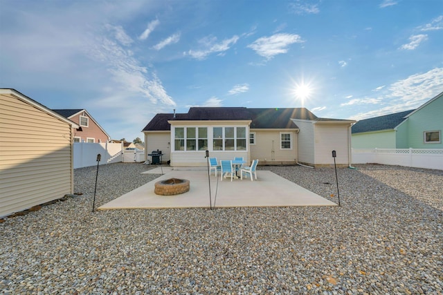 rear view of house featuring a patio, an outdoor fire pit, and a fenced backyard