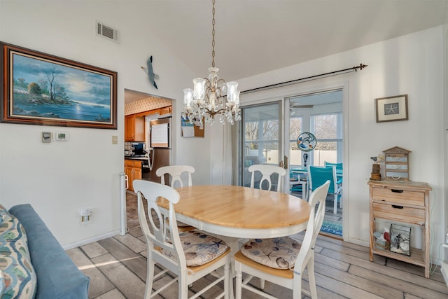 dining space featuring a chandelier, light wood-type flooring, visible vents, and baseboards