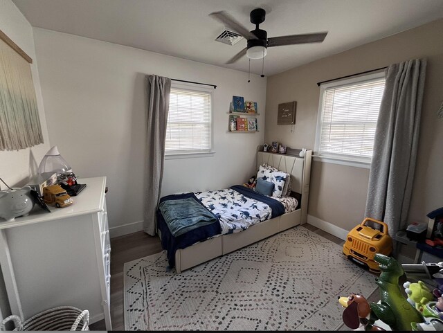 bedroom featuring baseboards, multiple windows, and visible vents