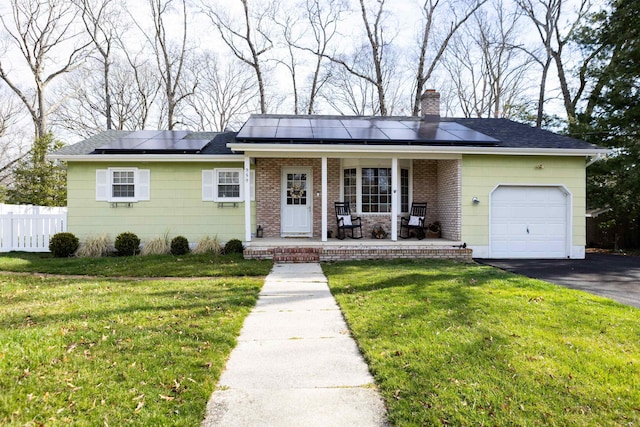 ranch-style home with fence, an attached garage, a front yard, a porch, and a chimney