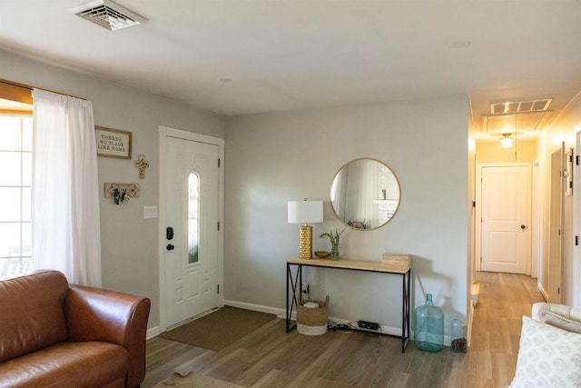 entrance foyer with visible vents, wood finished floors, and a healthy amount of sunlight