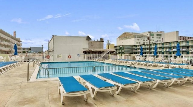 community pool with fence and a patio