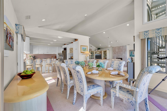 dining space featuring recessed lighting, visible vents, a tiled fireplace, and vaulted ceiling