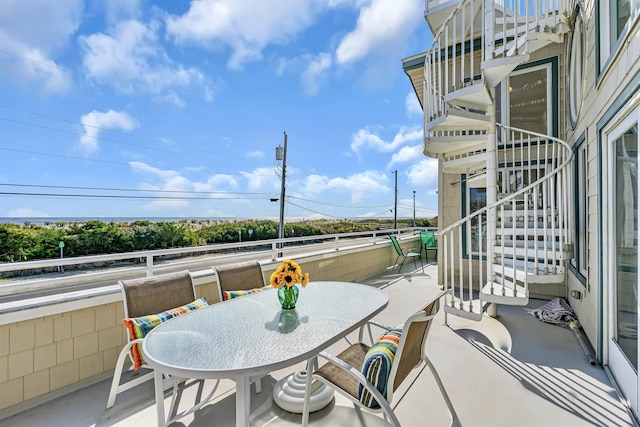 view of patio with stairway and a balcony