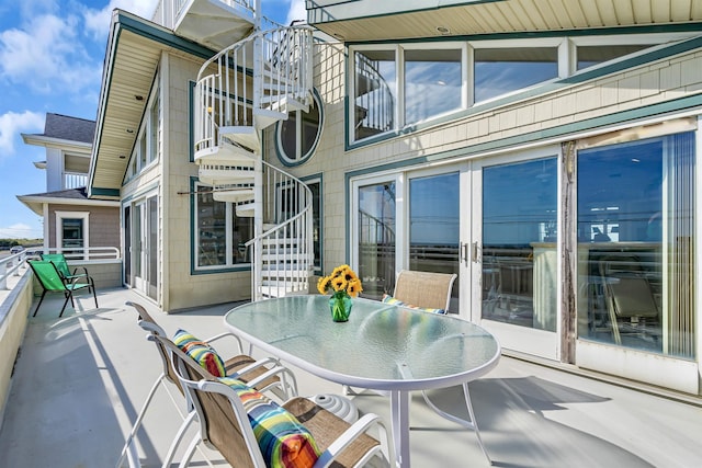 view of patio / terrace with outdoor dining space, french doors, and stairs