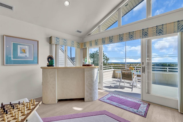 interior space featuring wood finished floors, visible vents, and high vaulted ceiling