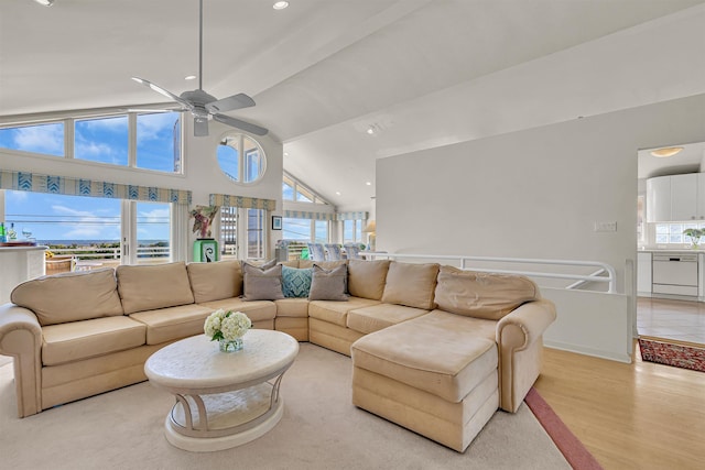 living room with a wealth of natural light, light wood-type flooring, high vaulted ceiling, and ceiling fan