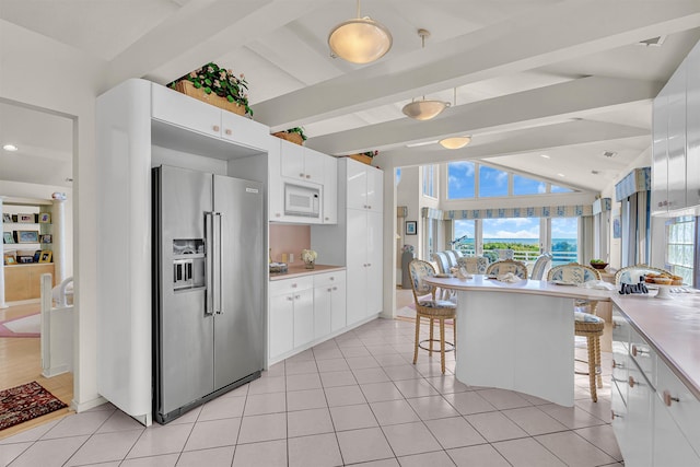 kitchen featuring lofted ceiling with beams, white cabinets, white microwave, and high end refrigerator