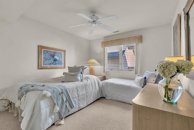 bedroom with a ceiling fan, visible vents, and light carpet