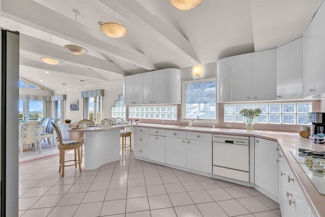 kitchen with white appliances, a wealth of natural light, light tile patterned floors, and lofted ceiling