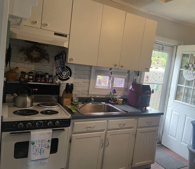 kitchen with decorative backsplash, white electric range, white cabinets, and sink