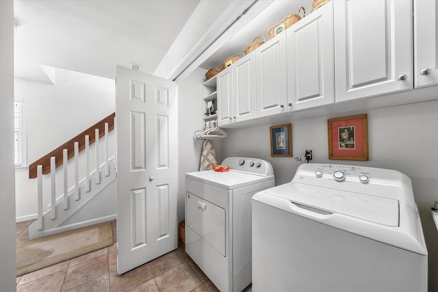 laundry area with light tile patterned floors, washing machine and dryer, and cabinet space