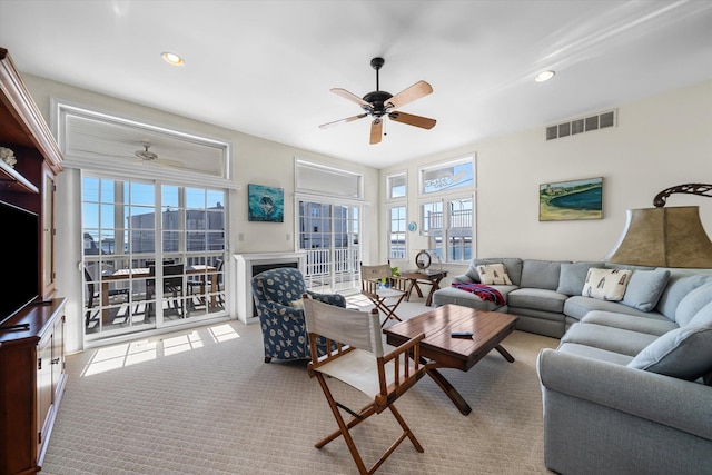 carpeted living area featuring a ceiling fan, recessed lighting, visible vents, and plenty of natural light