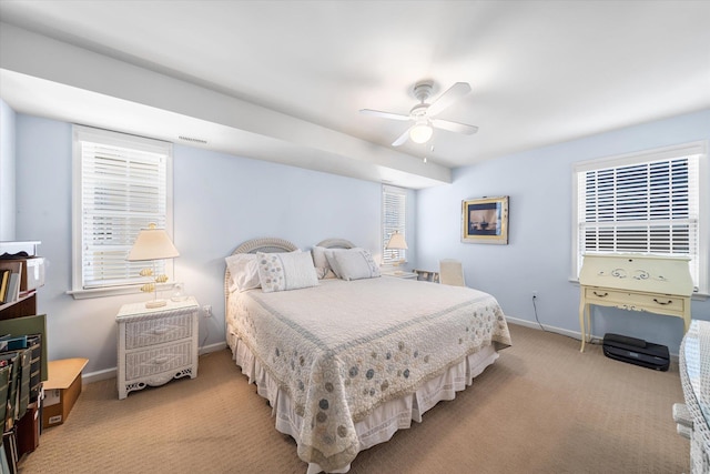 bedroom featuring light carpet, multiple windows, visible vents, and baseboards