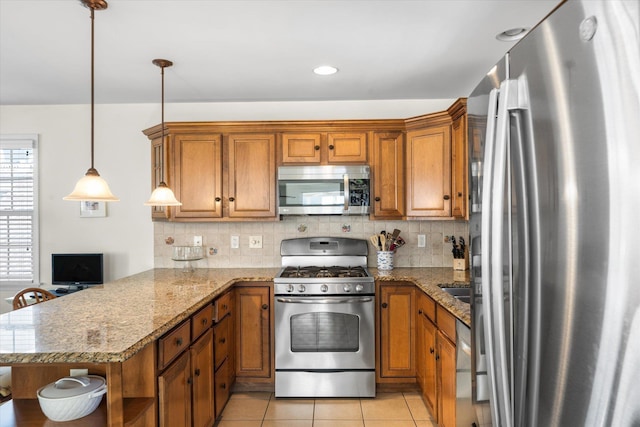 kitchen featuring light tile patterned floors, stainless steel appliances, decorative backsplash, brown cabinetry, and a peninsula