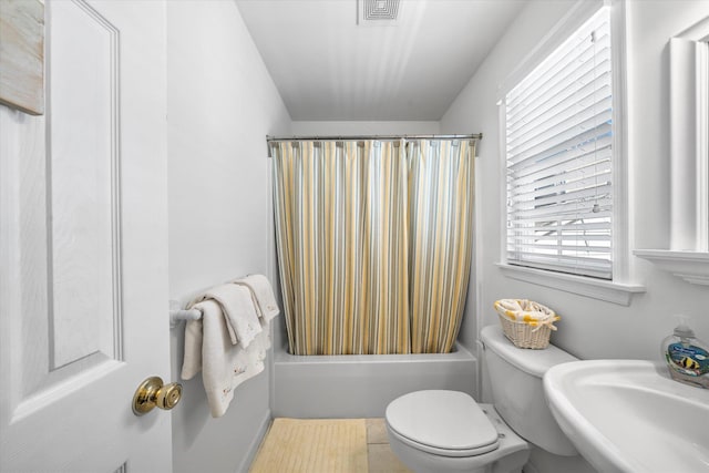 full bath featuring visible vents, a sink, shower / bathtub combination with curtain, and toilet