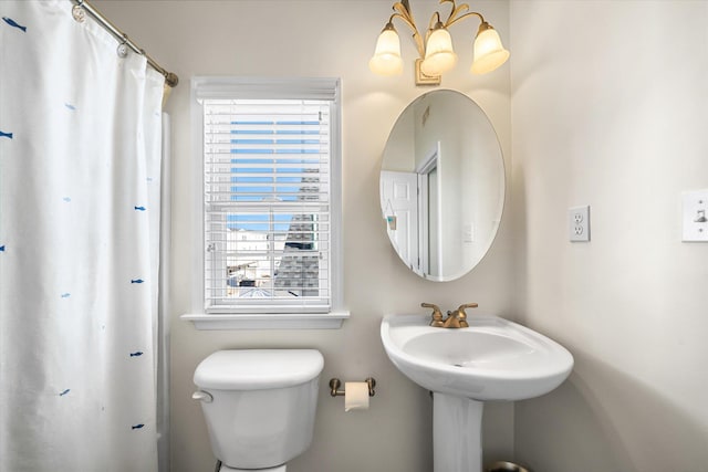 bathroom featuring toilet and an inviting chandelier