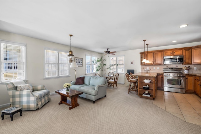 living area with light tile patterned flooring, recessed lighting, light colored carpet, a ceiling fan, and baseboards