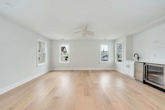 520 21st St, Avalon, NJ 08202 - unfurnished living room with wine cooler, light wood-style floors, ceiling fan, and bar