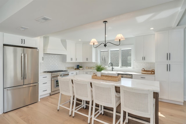 520 21st St, Avalon, NJ 08202 - kitchen featuring stainless steel appliances, custom exhaust hood, backsplash, light wood-style floors, and recessed lighting