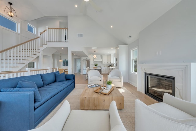 520 21st St, Avalon, NJ 08202 - living area with light wood finished floors, high vaulted ceiling, a premium fireplace, stairway, and healthy amount of natural light
