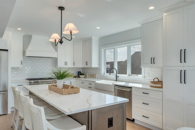 520 21st St, Avalon, NJ 08202 - kitchen featuring premium range hood, stainless steel appliances, decorative backsplash, a center island, and white cabinets