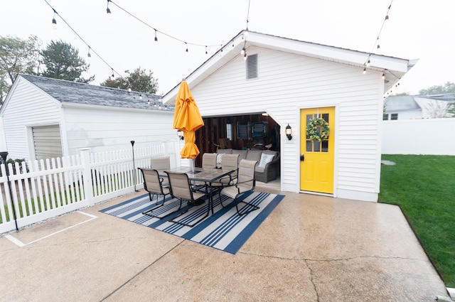 view of patio with outdoor dining space, an outdoor structure, a fenced backyard, and an outdoor living space