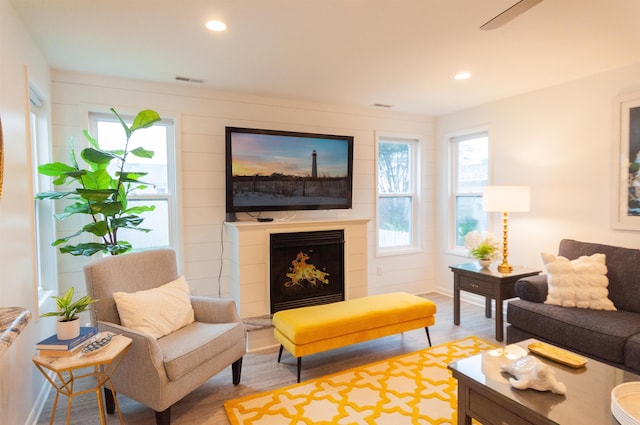 living room featuring a fireplace, visible vents, wood finished floors, and recessed lighting