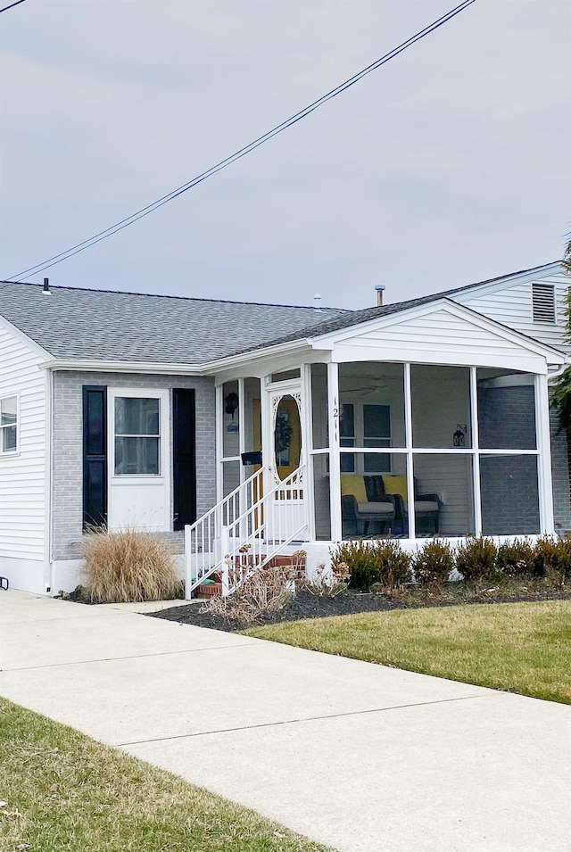 view of front of home with brick siding and roof with shingles