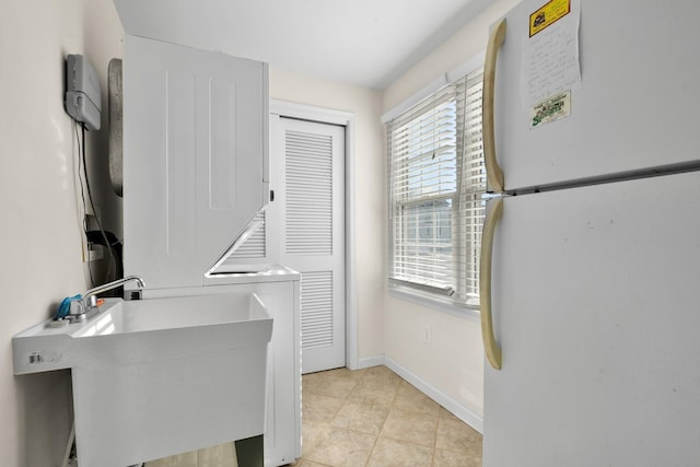 367 21st St, Avalon, NJ 08202 - laundry area featuring stacked washer / dryer, light tile patterned flooring, and baseboards