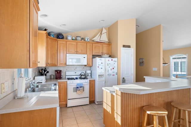 367 21st St, Avalon, NJ 08202 - kitchen with white appliances, a sink, tasteful backsplash, a breakfast bar, and light countertops