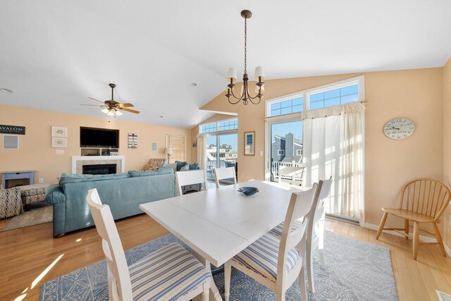 367 21st St, Avalon, NJ 08202 - dining room featuring healthy amount of natural light, a chandelier, light wood-style flooring, a fireplace, and high vaulted ceiling