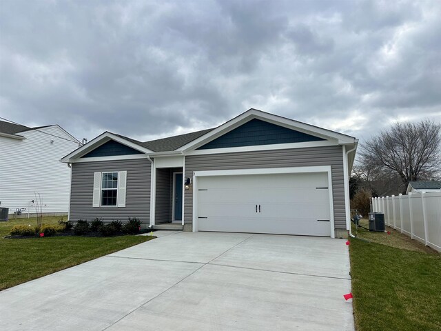 single story home with central AC, a front lawn, and a garage