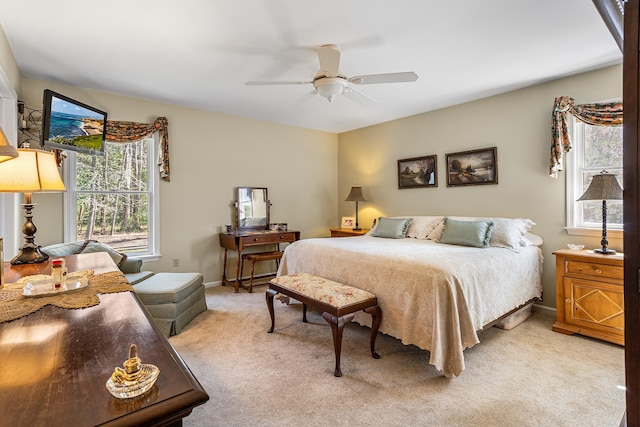 bedroom featuring ceiling fan, light colored carpet, and baseboards
