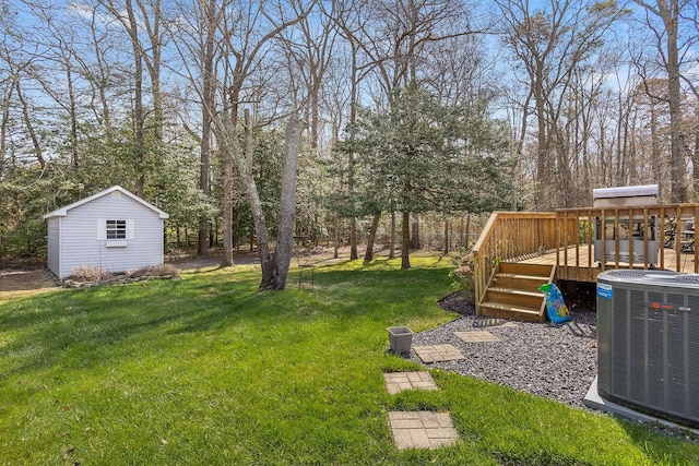 view of yard with central air condition unit, a wooden deck, and an outbuilding