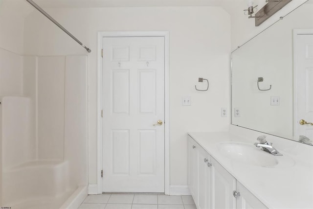 full bathroom with tile patterned flooring, vanity, baseboards, and walk in shower