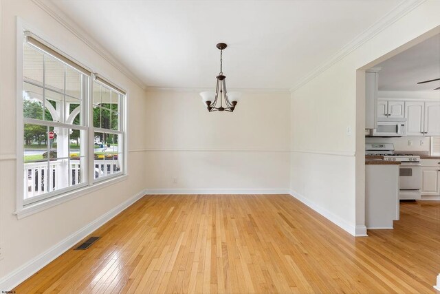 unfurnished dining area featuring visible vents, a notable chandelier, ornamental molding, light wood-style flooring, and baseboards