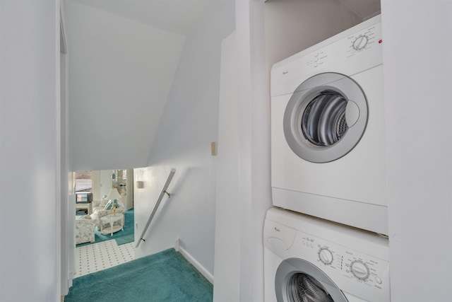 laundry area with laundry area, baseboards, carpet floors, and stacked washer / dryer