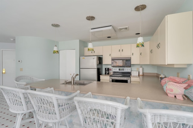 kitchen featuring stainless steel electric range, black microwave, a sink, freestanding refrigerator, and visible vents